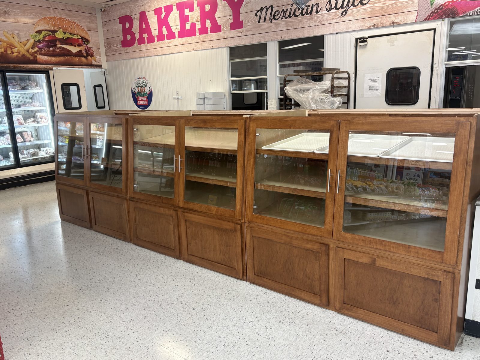 Wood self-serve bakery display cases with glass doors in a Mexican-style bakery