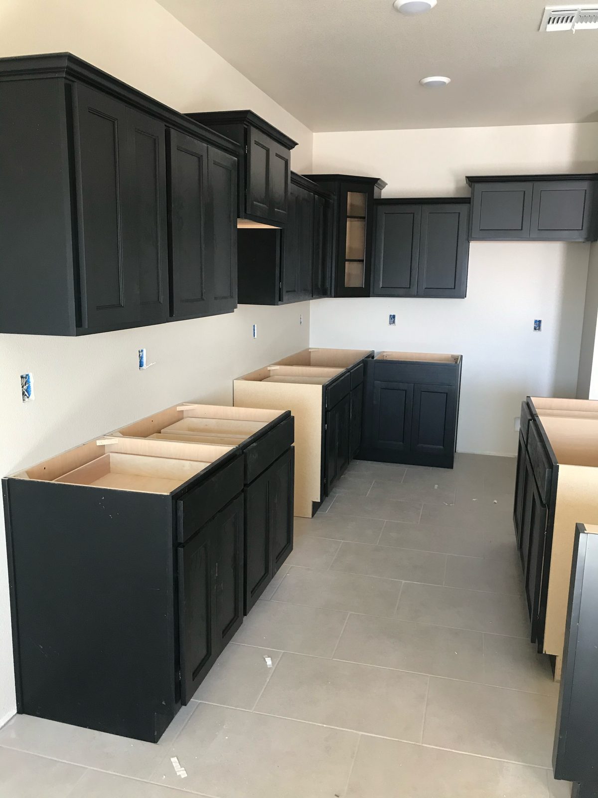 Black shaker kitchen cabinets during installation