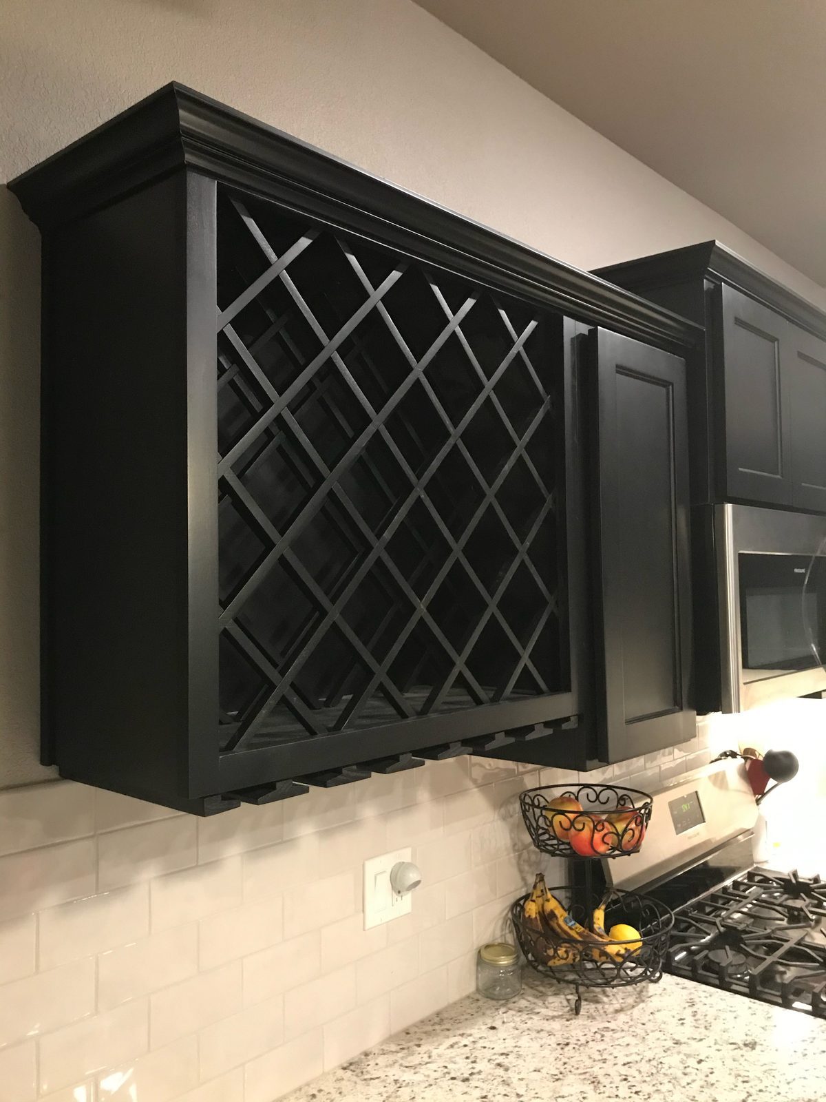Black wine rack cabinet above a granite counter