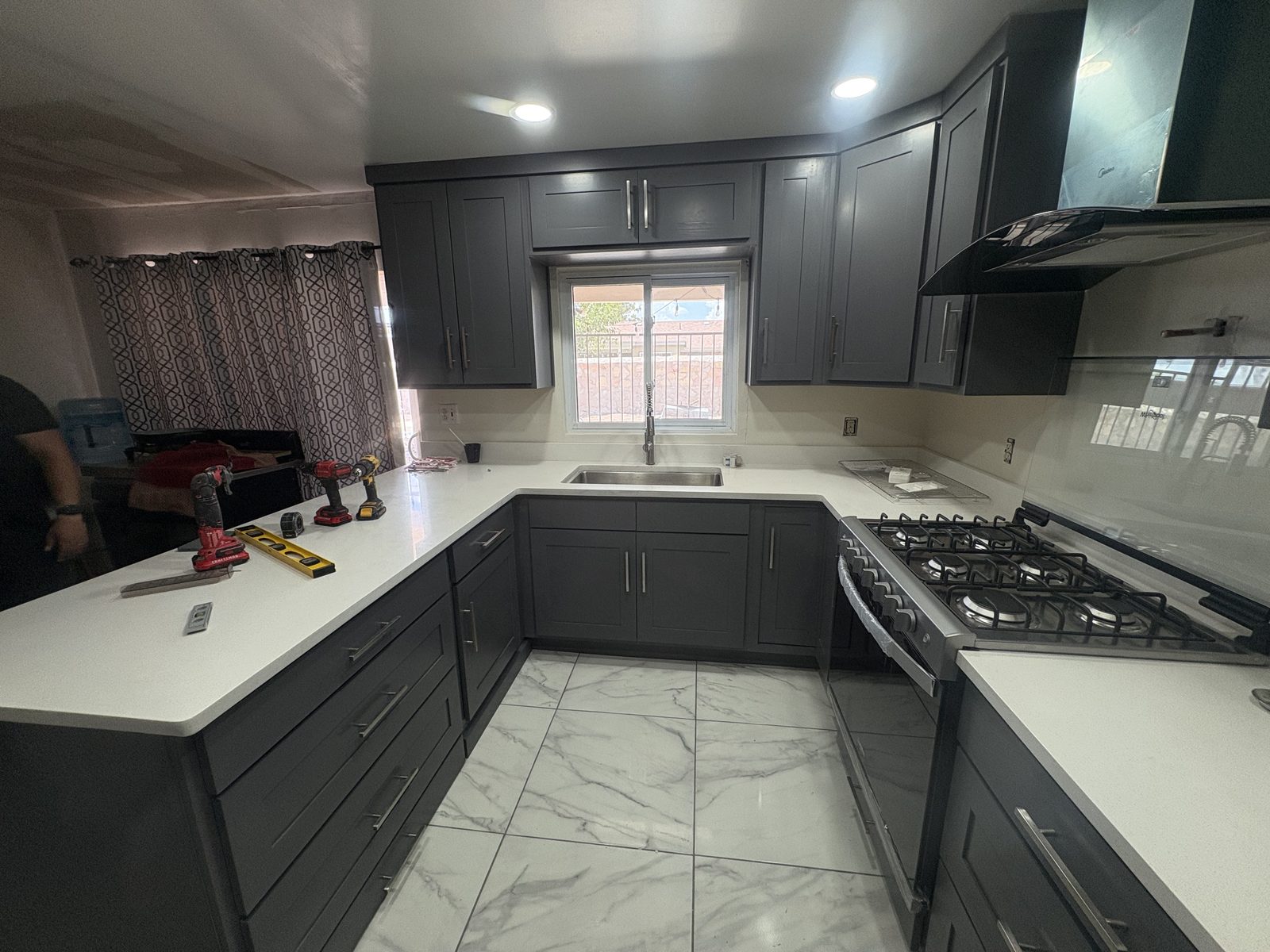 Charcoal shaker kitchen with white quartz countertops and marble-look tile floor