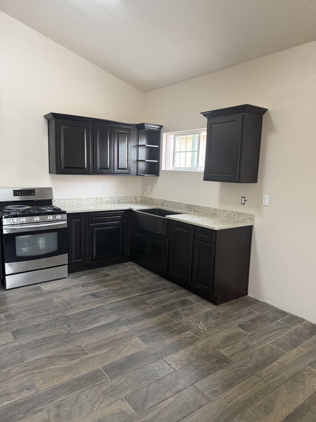 Espresso shaker kitchen with granite countertops and stainless range