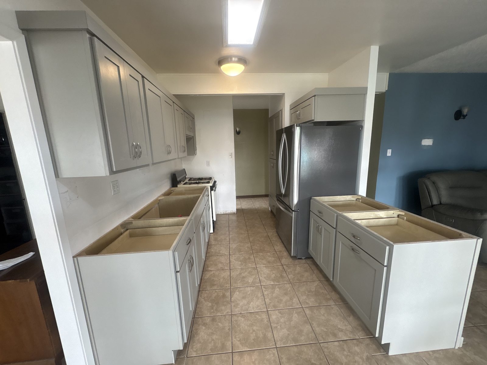 Gray shaker galley kitchen with island before countertops